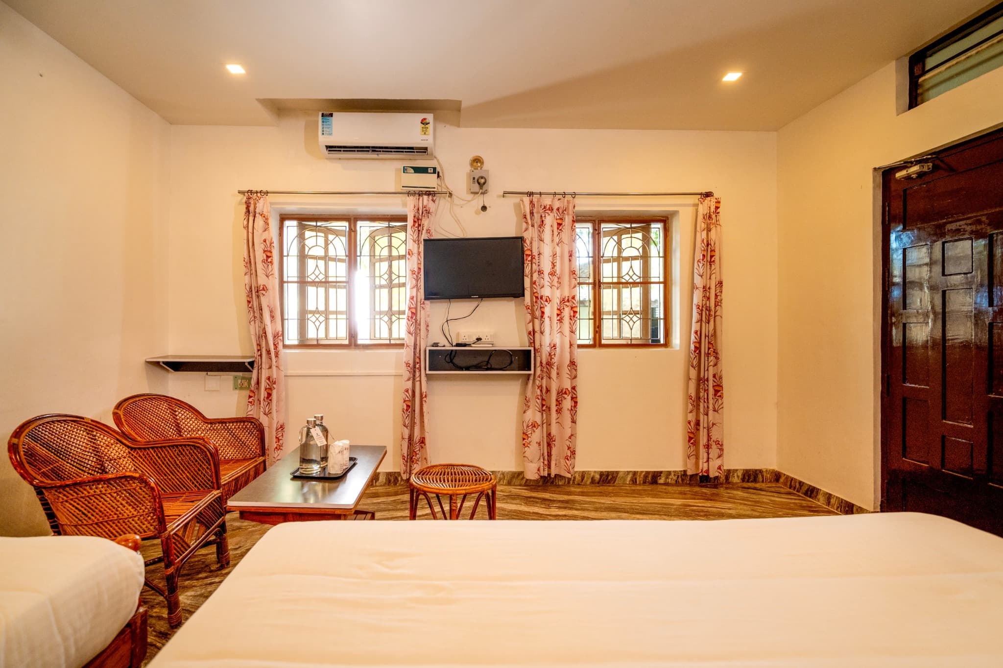 Triple Room with King and Single Bed, TV, windows and cane chairs