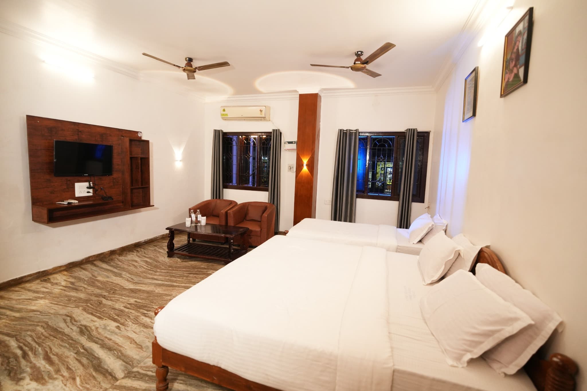 Triple Room with King and Single Bed, beds facing TV and armchairs