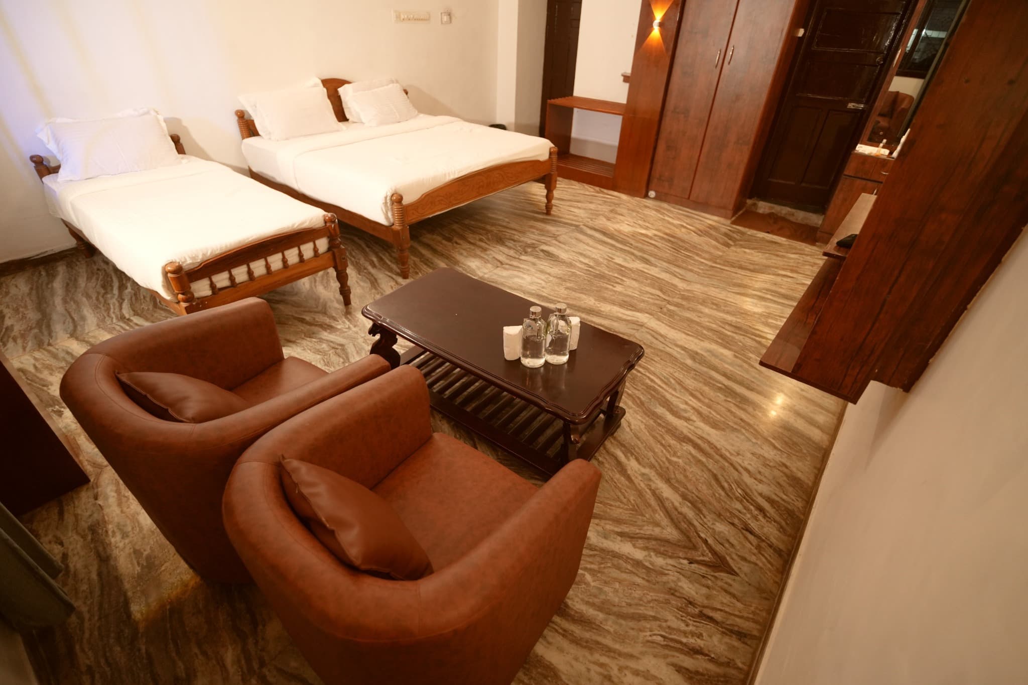 Triple Room with King and Single Bed, large and single bed overview with brown armchairs
